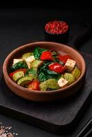 Delicious fresh salad of zucchini, cheese, sweet peppers, spinach with spices and herbs photo