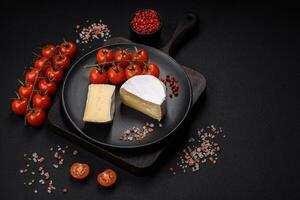 delicioso Fresco queso Brie queso en el formar de un mini cabeza con Cereza Tomates foto