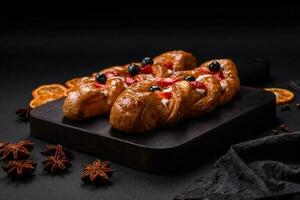 delicioso Fresco crujiente Pastelería en el formar de un coleta con fresas y arándanos foto