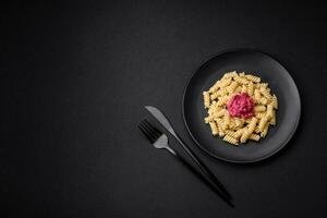 Delicious fusilli pasta with beetroot pesto, parmesan, salt and spices photo