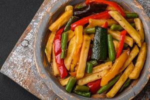 Delicious fried potatoes with bell peppers, asparagus beans, salt and spices photo