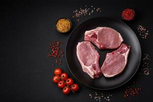 Raw pork on the bone or rib sliced with salt, spices and herbs photo