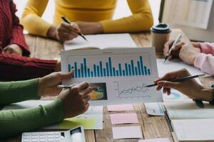 Financial analysts analyze business financial reports on a digital tablet planning investment project during a discussion at a meeting of corporate showing the results of their successful teamwork. photo