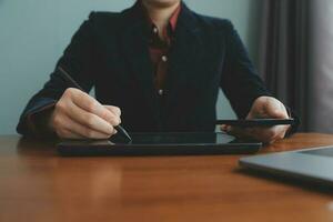 Corporate Communication. Asian Businesswoman Talking On Mobile Phone Working On Laptop In Modern Office. Free Space photo