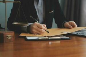 Business and lawyers discussing contract papers with brass scale on desk in office. Law, legal services, advice, justice and law concept picture with film grain effect photo