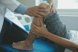 Doctor or physical therapist examines back pain and spinal area to give advice within the rehabilitation center. photo