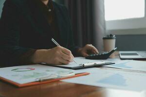 Group of confident business people point to graphs and charts to analyze market data, balance sheet, account, net profit to plan new sales strategies to increase production capacity. photo