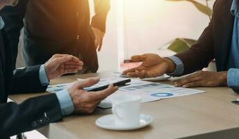 Financial analysts analyze business financial reports on a digital tablet planning investment project during a discussion at a meeting of corporate showing the results of their successful teamwork. photo