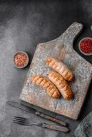 Delicious grilled sausages from chicken or pork meat with salt, spices and herbs photo