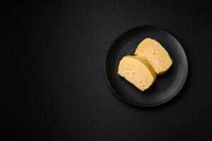 Delicious porous yellow cheese cut in large pieces on a ceramic plate photo