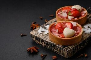 Delicious fresh sweet tartlets with strawberries and coconut flakes photo
