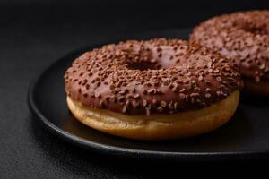 Delicious chocolate glazed donut sprinkled with chocolate chips photo