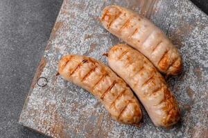 Delicious grilled sausages from chicken or pork meat with salt, spices and herbs photo