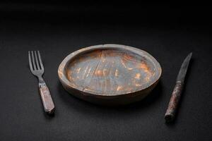 Empty wooden plate, knife, fork and cutting board photo