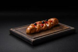 Delicious fresh crispy pastry in the form of a pigtail with strawberries and blueberries photo