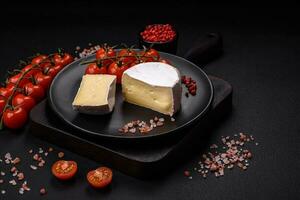 delicioso Fresco queso Brie queso en el formar de un mini cabeza con Cereza Tomates foto