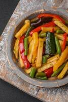 Delicious fried potatoes with bell peppers, asparagus beans, salt and spices photo