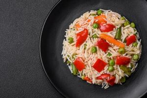 Delicious boiled rice with peppers, peas, asparagus beans and carrots photo