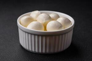 Delicious fresh mozzarella cheese in the form of small balls with salt and spices photo