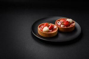 Delicious fresh sweet tartlets with strawberries and coconut flakes photo