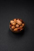 Pecan nuts in shell and peeled in a wooden round bowl photo