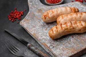 Delicious grilled sausages from chicken or pork meat with salt, spices and herbs photo