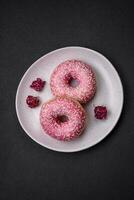 Delicious fresh sweet donuts in pink glaze with strawberry filling photo