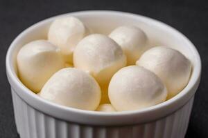 Delicious fresh mozzarella cheese in the form of small balls with salt and spices photo