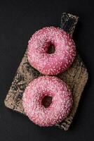 Delicious fresh sweet donuts in pink glaze with strawberry filling photo