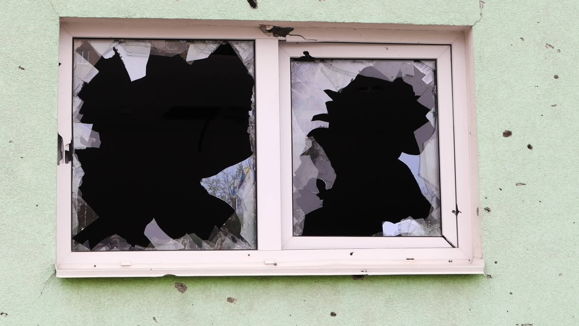 An outside view of a broken window in a building. The concept of street