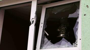 un fuera de ver de un roto ventana en un edificio. el concepto de calle delito, vandalismo, delincuente actividad, robo, antisocial violento comportamiento. grande fragmentos de vaso en un roto ventana. video