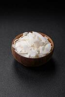 White dry coconut flakes in a wooden bowl prepared for making desserts photo