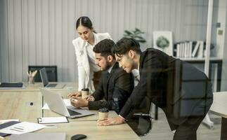 Financial advisors collaborate to assess a company's financial performance using data from its operational activities. Team members work together in a discussions meeting to develop a business plan. photo