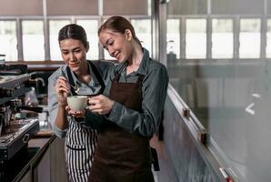 Young adult coffee makers work with skilled baristas to create menus. Using a coffee machine to make hot and cold coffee. Experiment with grinding and blending, including adding milk foam on top. photo