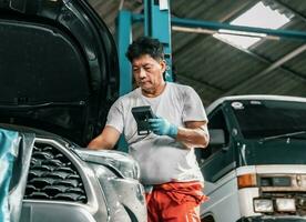 Experienced auto mechanics inspect car battery terminals and voltage to identify the cause of errors or defects. Perform diagnosis, repair, replace, and remove mechanical and electrical components. photo