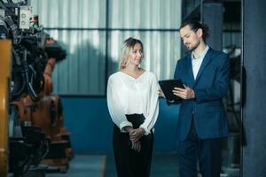 Robotic factory owner explain, discuss functionality and performance of robot systems with client. Answering questions about after-sales service. Price negotiation. Developing long-term relationships photo