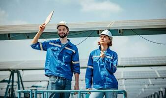 Solar engineers visually examine panel arrays on farm sites using blueprints and drawings to ensure that the alignment, surface, sunlight access, and structural stability meet standard requirements. photo