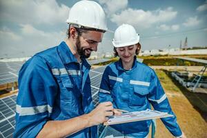 Solar engineers visually examine panel arrays on farm sites using blueprints and drawings to ensure that the alignment, surface, sunlight access, and structural stability meet standard requirements. photo