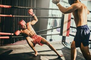 Boxer utilizar varios puñetazo combinaciones, incluso el pinchazo, gancho, uppercut, cruz, balancearse, derecho. consiguiendo en cerca a hacer adversario en cuerdas y knockear. boxeo campeones ganar el redondo en boxeo anillo foto