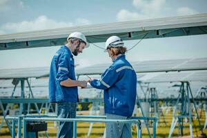 Solar engineers visually examine panel arrays on farm sites using blueprints and drawings to ensure that the alignment, surface, sunlight access, and structural stability meet standard requirements. photo