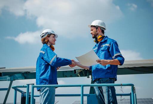 Solar engineers visually examine panel arrays on farm sites using blueprints and drawings to ensure that the alignment, surface, sunlight access, and structural stability meet standard requirements. photo
