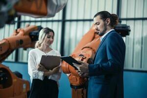 Robotic factory owner explain, discuss functionality and performance of robot systems with client. Answering questions about after-sales service. Price negotiation. Developing long-term relationships photo