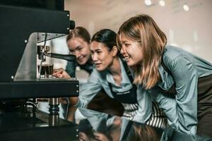 Young adult coffee makers work with skilled baristas to create menus. Using a coffee machine to make hot and cold coffee. Experiment with grinding and blending, including adding milk foam on top. photo