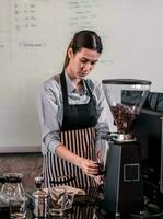 Young adult coffee makers work with skilled baristas to create menus. Using a coffee machine to make hot and cold coffee. Experiment with grinding and blending, including adding milk foam on top. photo