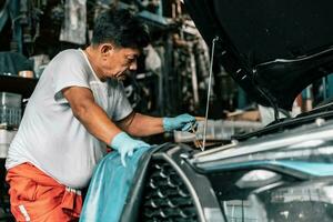 auto mecánico diagnosticar y soluciona problemas con herramientas y equipo. pulido auto, fijación frenado y direccion sistemas medición petróleo niveles con petróleo calibre palo y luego torrencial o cambiando él. foto