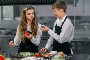 Teenagers learn from expert chefs at culinary school to prepare ingredients and create a variety of tasty meals. A practical activity connected their senses of taste and smell is making hamburgers. photo