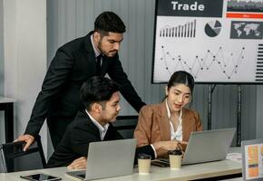 Financial advisors collaborate to assess a company's financial performance using data from its operational activities. Team members work together in a discussions meeting to develop a business plan. photo
