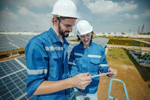 Solar engineers visually examine panel arrays on farm sites using blueprints and drawings to ensure that the alignment, surface, sunlight access, and structural stability meet standard requirements. photo