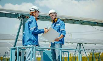 Solar engineers visually examine panel arrays on farm sites using blueprints and drawings to ensure that the alignment, surface, sunlight access, and structural stability meet standard requirements. photo