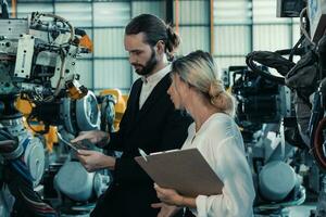 Robotic factory owner explain, discuss functionality and performance of robot systems with client. Answering questions about after-sales service. Price negotiation. Developing long-term relationships photo